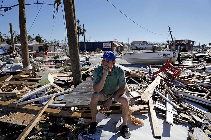 Hector Morales sits on a debris pile near his home which was destroyed by hurricane Michael in Mexico Beach, Fla., Friday, Oct. 12, 2018. "I have nothing else to do. I'm just waiting," said Morales as he wonders what he will do next. "I lost everything." (AP Photo/David Goldman)