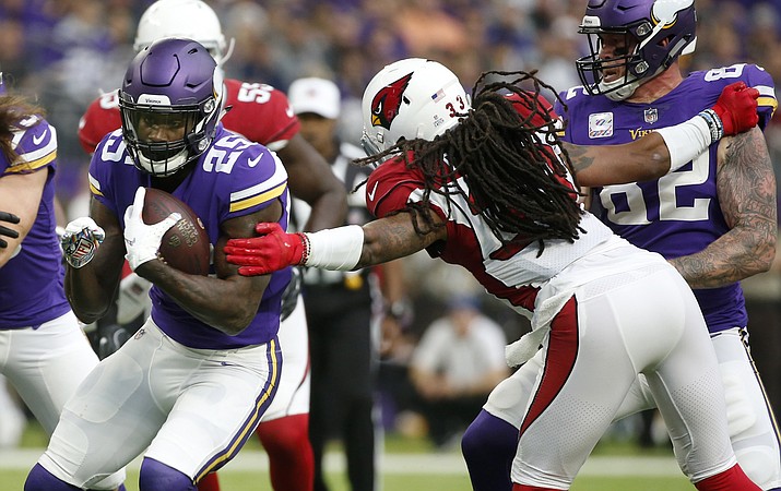 Minnesota Vikings running back Latavius Murray (25) breaks a tackle by Arizona Cardinals defensive back Tre Boston, right, during a 21-yard touchdown run in the first half of an NFL football game, Sunday, Oct. 14, 2018, in Minneapolis. (Bruce Kluckhohn/AP)