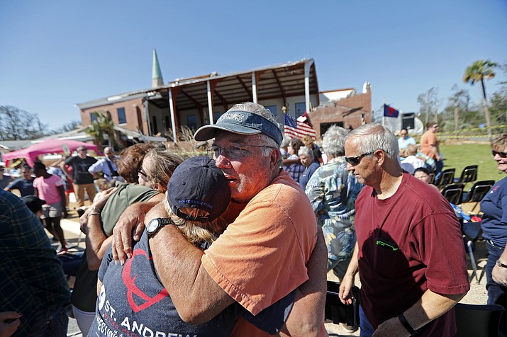 Jerry Register, a congregation member of St. Andrew United Methodist Church, hugs a fellow church member during Sunday service, outside the damaged church in the aftermath of Hurricane Michael in Panama City, Fla., Sunday, Oct. 14, 2018. (Gerald Herbert/AP)
