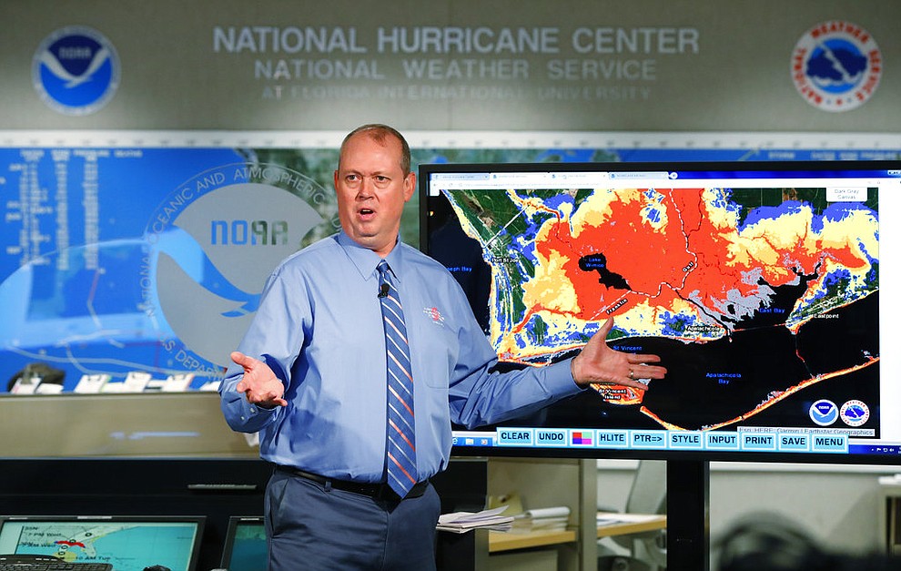 National Hurricane Center director Ken Graham, gestures as he talks about storm surge during a televised update on the status of Hurricane Michael, Tuesday, Oct. 9, 2018, at the Hurricane Center in Miami. At least 120,000 people along the Florida Panhandle were ordered to clear out Tuesday as Hurricane Michael rapidly picked up steam in the Gulf of Mexico and closed in with winds of 110 mph (175 kph) and a potential storm surge of 12 feet (3.7 meters). (AP Photo/Wilfredo Lee)