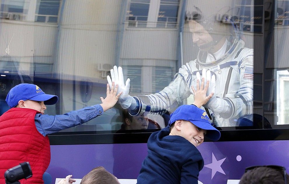 U.S. astronaut Nick Hague, member of the main crew to the International Space Station (ISS), waves to his sons from a bus prior to the launch of Soyuz-FG rocket at the Russian leased Baikonur cosmodrome, Kazakhstan, Thursday, Oct. 11, 2018. (AP Photo/Dmitri Lovetsky, Pool)