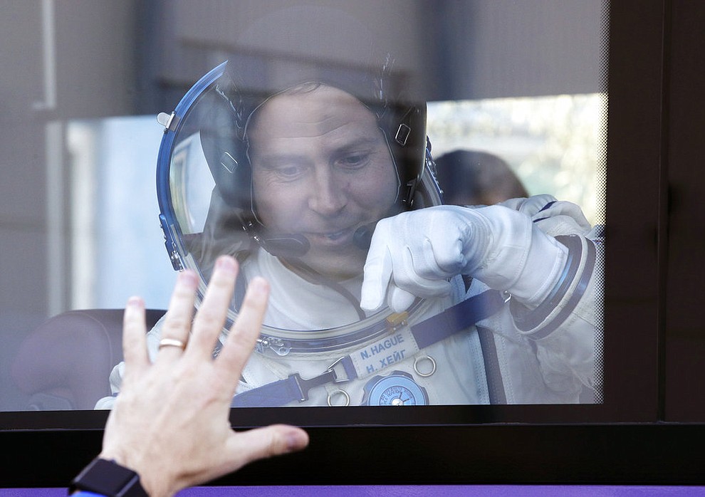 U.S. astronaut Nick Hague, member of the main crew to the International Space Station (ISS), waves to his relatives from a bus prior to the launch of Soyuz-FG rocket at the Russian leased Baikonur cosmodrome, Kazakhstan, Thursday, Oct. 11, 2018. (AP Photo/Dmitri Lovetsky, Pool)