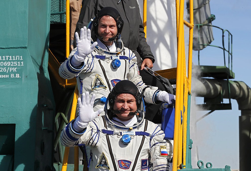 U.S. astronaut Nick Hague, right, and Russian cosmonaut Alexey Ovchinin, crew members of the mission to the International Space Station wave as they board the rocket prior to the launch of Soyuz-FG rocket at the Russian leased Baikonur cosmodrome, Kazakhstan, Thursday, Oct. 11, 2018. (Yuri Kochetkov, Pool Photo via AP)