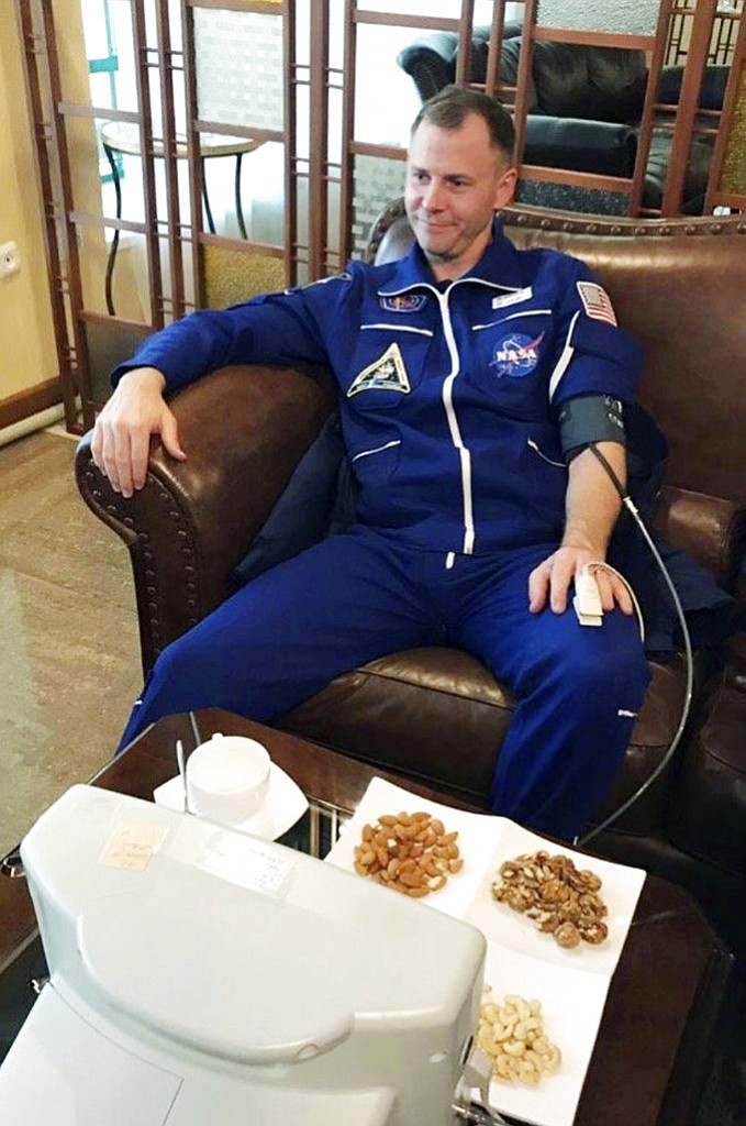 In this photo provided by Roscosmos, NASA astronaut Nick Hague sits in a hall after being transported by the rescue team, in Dzhezkazgan, about 450 kilometers (280 miles) northeast of Baikonur, Kazakhstan, Thursday, Oct. 11, 2018. Two astronauts from the U.S. and Russia were safe Thursday after an emergency landing in the steppes of Kazakhstan following the failure of a Russian booster rocket carrying them to the International Space Station. (Roscosmos via AP)
