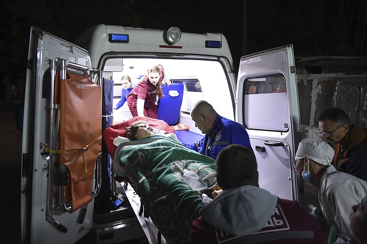 Medics load an injured person onto an ambulance, in Kerch, Crimea, Wednesday Oct. 17, 2018. Russian officials says an 18-year-old student attacked his vocational school in Crimea, going on a rampage that killed 17 students and left more than 40 people wounded before killing himself. (Viktor Korotaev/Kommersant Photo via AP)