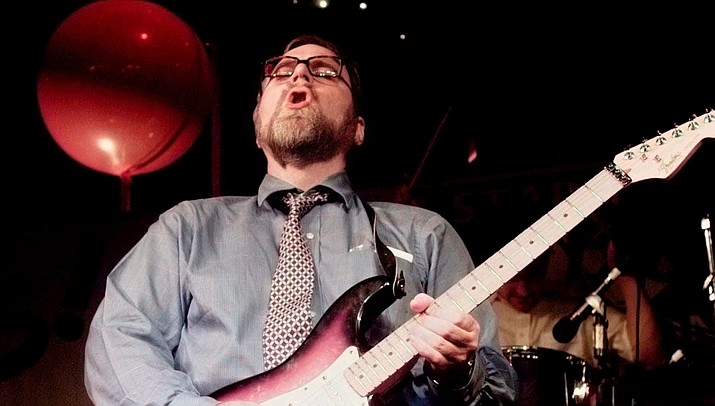 In this June 18, 1997, file photo, Microsoft co-founder and billionaire Paul Allen joins in with the band and plays electric guitar at an election night victory party in the early morning hours in Seattle. (Elaine Thompson/AP, file)