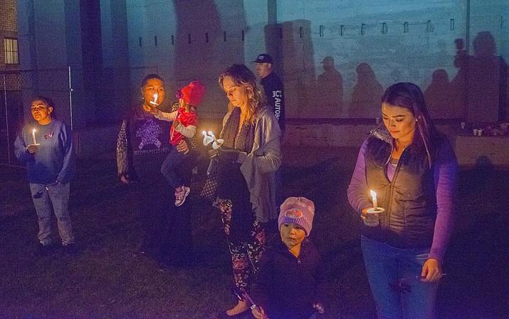 Around 40 people gather in downtown Winslow Oct. 18 at a candlelight vigil to help raise awareness of domestic violence. (Todd Roth/NHO)