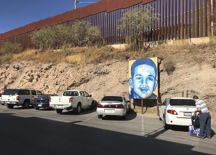 In this Dec. 4, 2017, file photo, a portrait of 16-year-old Mexican youth Jose Antonio Elena Rodriguez, who was shot and killed in Nogales, Sonora, Mexico, is displayed on the Nogales street where he was killed that runs parallel with the U.S. border. A U.S. Border Patrol agent will face a second trial Tuesday, Oct. 23, 2018, in the killing of Elena Rodriguez across the international border. Lonnie Swartz was acquitted of second-degree murder in Tucson earlier in 2018 and now will be tried on voluntary and involuntary manslaughter charges. (Anita Snow/AP, File)
