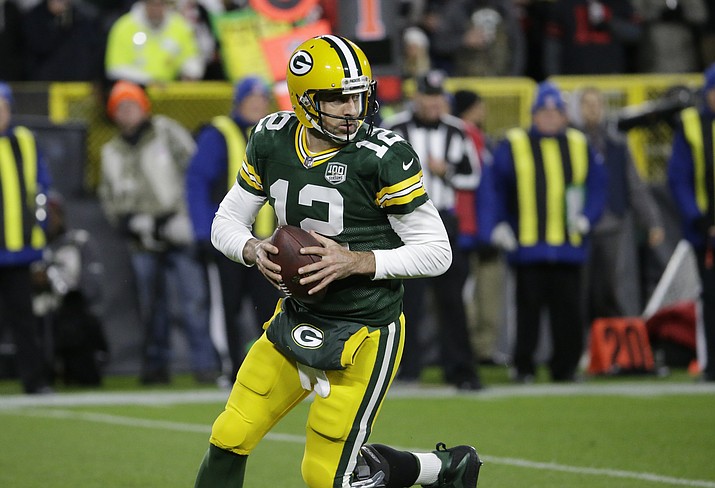 Green Bay Packers quarterback Aaron Rodgers (12) rolls out to pass against the San Francisco 49ers during the first half of an NFL football game Monday, Oct. 15, 2018, in Green Bay, Wis. (Mike Roemer/AP)