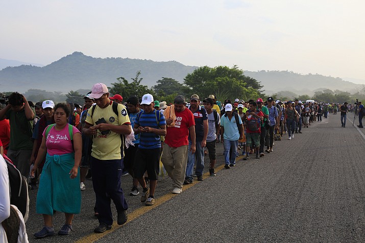 Migrants walk along the road after Mexico's federal police briefly blocked the highway in an attempt to stop a thousands-strong caravan of Central American migrants from advancing, outside the town of Arriaga, Mexico, Saturday, Oct. 27, 2018. Hundreds of Mexican federal officers carrying plastic shields had blocked the caravan from advancing toward the United States, after several thousand of the migrants turned down the chance to apply for refugee status and obtain a Mexican offer of benefits. (Rebecca Blackwell/AP)