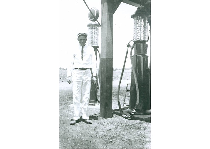 A gas pump and service attendant at the Clark  Car Camp service station, which was located on the east side of Williams. circa 1928. (Williams Historic Photo Archives, Kaibab National Forest Collection)