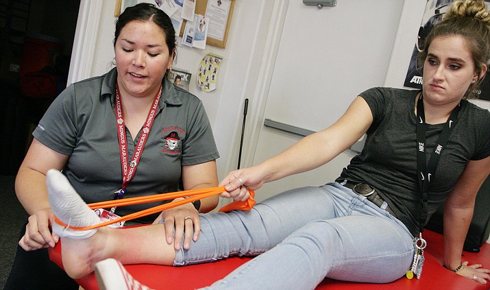 Jazmine Roland helps Mingus Union High School senior Lindsey Jones with her sprained ankle. Through a partnership between Northern Arizona Healthcare and the National Football League, Roland serves as athletic trainer at Mingus Union. VVN/Bill Helm