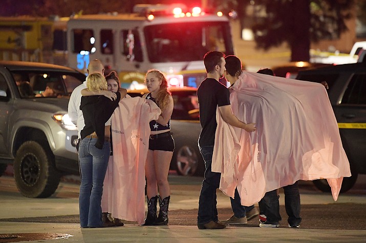 People comfort each other as they stand near the scene Thursday, Nov. 8, 2018, in Thousand Oaks, Calif. where a gunman opened fire Wednesday inside a country dance bar crowded with hundreds of people on "college night," wounding 11 people including a deputy who rushed to the scene. Ventura County sheriff's spokesman says gunman is dead inside the bar. (AP Photo/Mark J. Terrill)