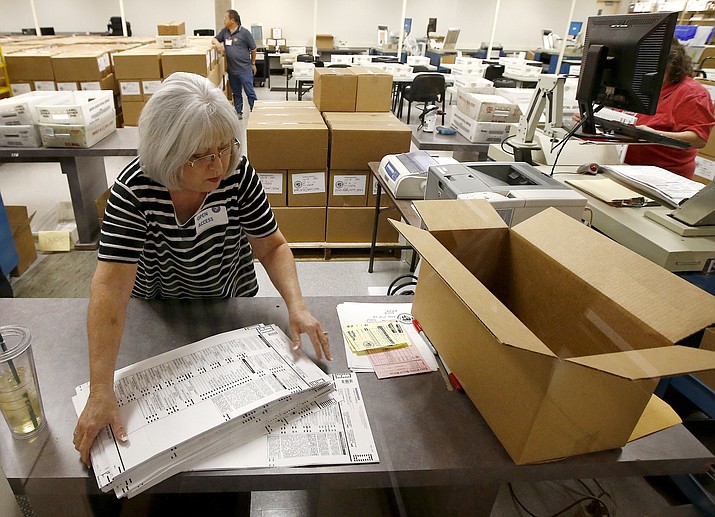 Workers at the Maricopa County Recorder's Office go through ballots Thursday, Nov. 8, 2018, in Phoenix. There are several races too close to call in Arizona, especially the Senate race between Democratic candidate Kyrsten Sinema and Republican candidate Martha McSally. (AP Photo/Ross D. Franklin)
