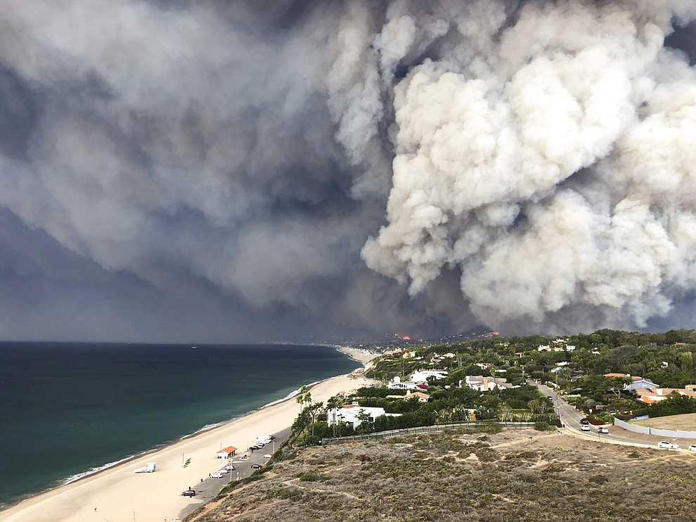In this Friday, Nov. 9, 2018 photo, smoke from the wildires fills the air in Malibu, Calif. Los Angeles County fire Chief Daryl Osby said Saturday that firefighters told him they were working in the toughest, most extreme conditions they had seen in their lives on Friday night. He says conditions are far better Saturday, with a lull in winds that are expected to return Sunday. (Courtesy of Ben Watkins via AP)