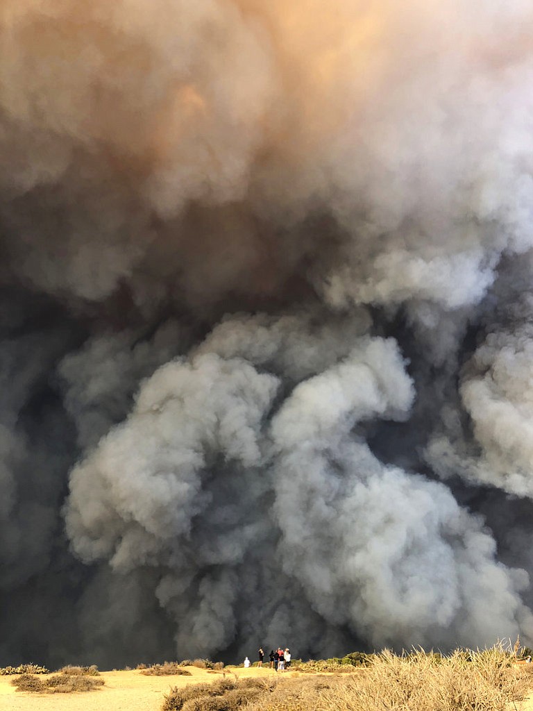 In this Friday, Nov. 9, 2018 photo, smoke from the wildires fills the air in Malibu, Calif. Los Angeles County fire Chief Daryl Osby said Saturday that firefighters told him they were working in the toughest, most extreme conditions they had seen in their lives on Friday night. He says conditions are far better Saturday, with a lull in winds that are expected to return Sunday. (Courtesy of Ben Watkins via AP)
