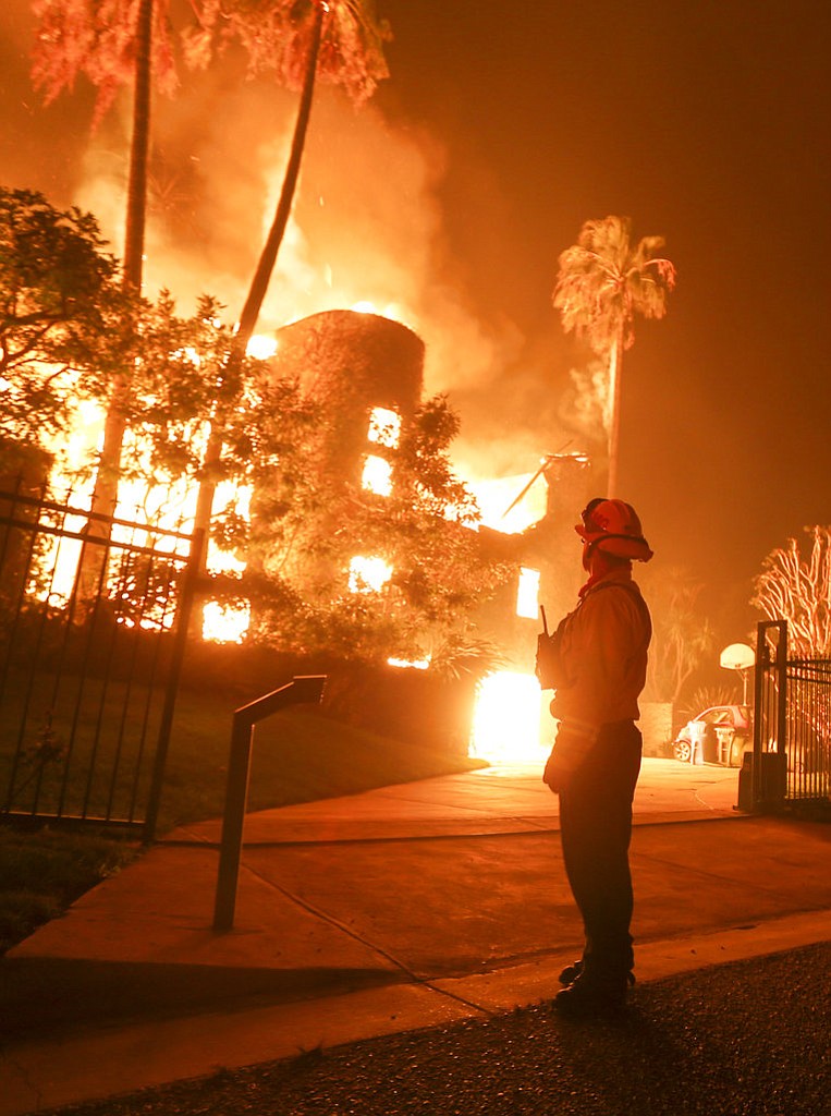 A firefighter keeps watch as the Woolsey Fire burns a home in Malibu, Calif., Friday, Nov. 9, 2018. A Southern California wildfire continues to burn homes as it runs toward the sea. Winds are blamed for pushing the fire through scenic canyon communities and ridgetop homes. (AP Photo/Ringo H.W. Chiu)