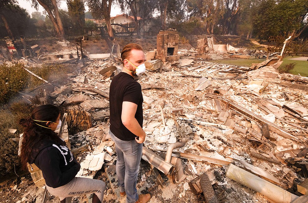 Alexander Tobolsky, right, and his girl friend Dina Arias, return to his home where burned out by the fire in Malibu, Calif., Saturday, Nov. 10, 2018. Officials took advantage of temporarily calm conditions Saturday to assess damage from the blaze that's burned 109 square miles outside downtown Los Angeles.(AP Photo/Ringo H.W. Chiu)