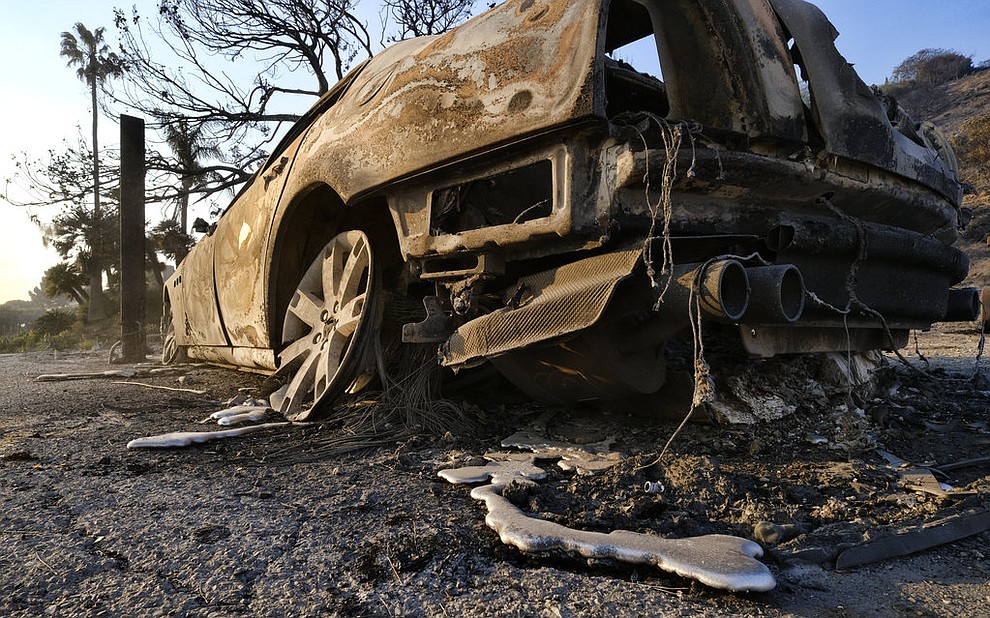 The charred out remains of a car that burned after a wildfire swept through along the Pacific Coast Highway in Malibu, Calif., on Saturday, Nov. 10, 2018. Firefighters have saved thousands of homes despite working in "extreme, tough fire conditions that they said they have never seen in their life," Los Angeles County Fire Chief Daryl Osby said. (AP Photo/Richard Vogel)