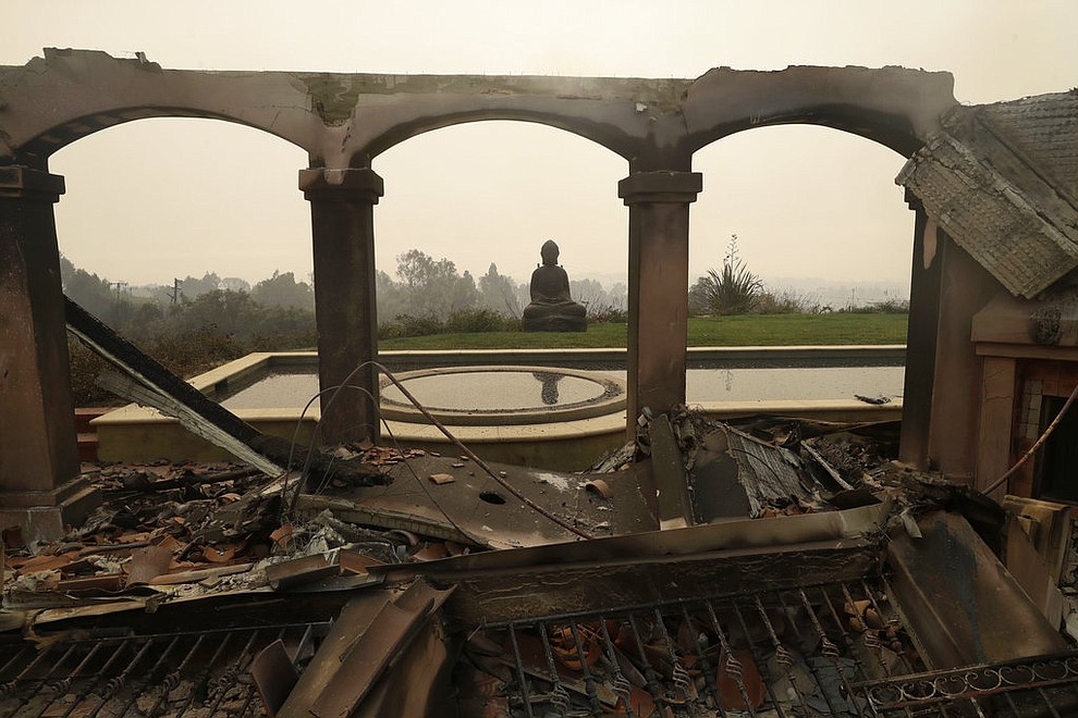 A Buddha statue stands among the damage caused by a wildfire at a home Saturday, Nov. 10, 2018, in Malibu, Calif. Scores of houses from ranch homes to celebrities' mansions burned in a pair of wildfires that stretched across more than 100 square miles of Southern California, authorities said Saturday. (AP Photo/Marcio Jose Sanchez)