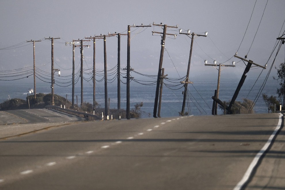 The remains of broken telephone poles line the Pacific Coast Highway which remained closed in both directions after a wildfire swept through to the area outside of Malibu, Calif. on Saturday Nov. 10, 2018. Firefighters have saved thousands of homes despite working in "extreme, tough fire conditions that they said they have never seen in their life," Los Angeles County Fire Chief Daryl Osby said. (AP Photo/Richard Vogel)