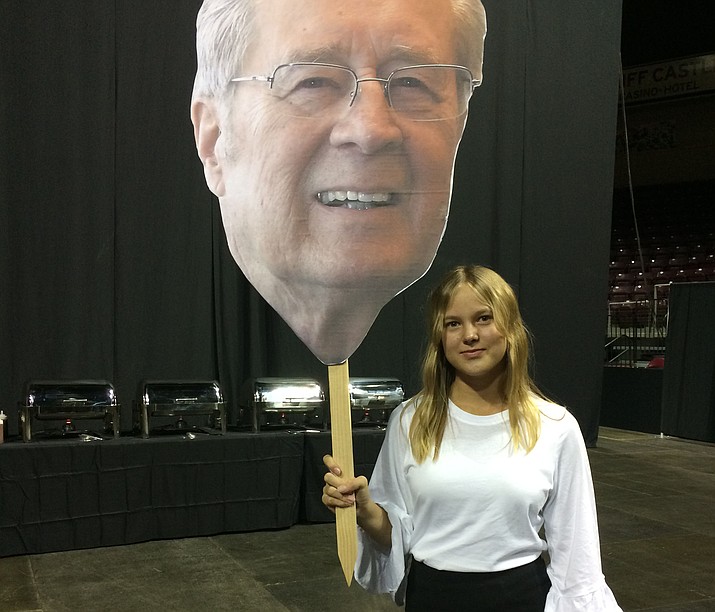 Prescott Valley Mayor Harvey Skoog’s poster-size photo is mounted on sticks. His granddaughter, Riina Skoog, holds one up as the party at the Prescott Valley Event Center Sunday night gets started. (Nanci Hutson/Courtesy)