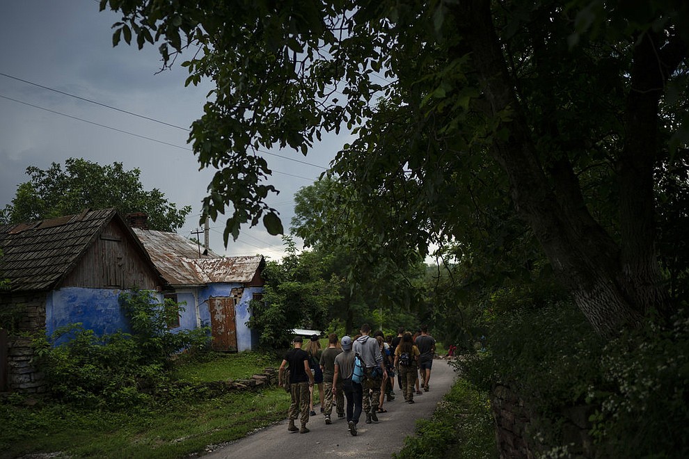In this July 27, 2018 photo, young participants of the "Temper of will" summer camp, organized by the Svoboda party, walk to a campsite in a village near Ternopil, Ukraine. The camp has two purposes: to train children to defend their country _ and to spread nationalist ideology. (AP Photo/Felipe Dana)