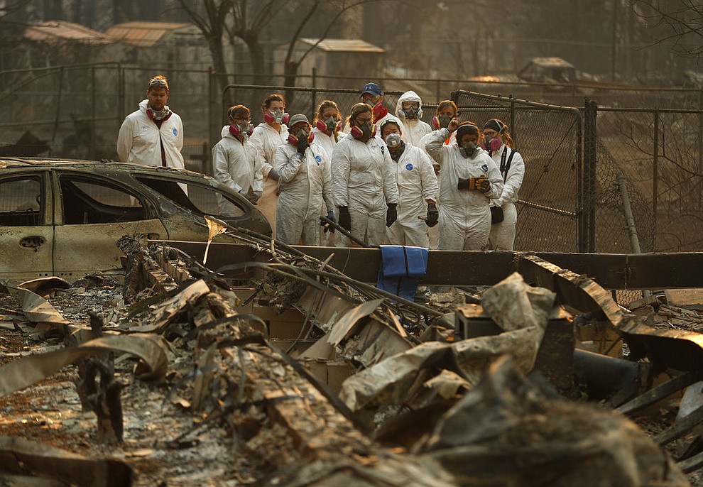 Anthropology students observe as human remains are recovered from a burned out home at the Camp Fire, Sunday, Nov. 11, 2018, in Paradise, Calif. (AP Photo/John Locher)
