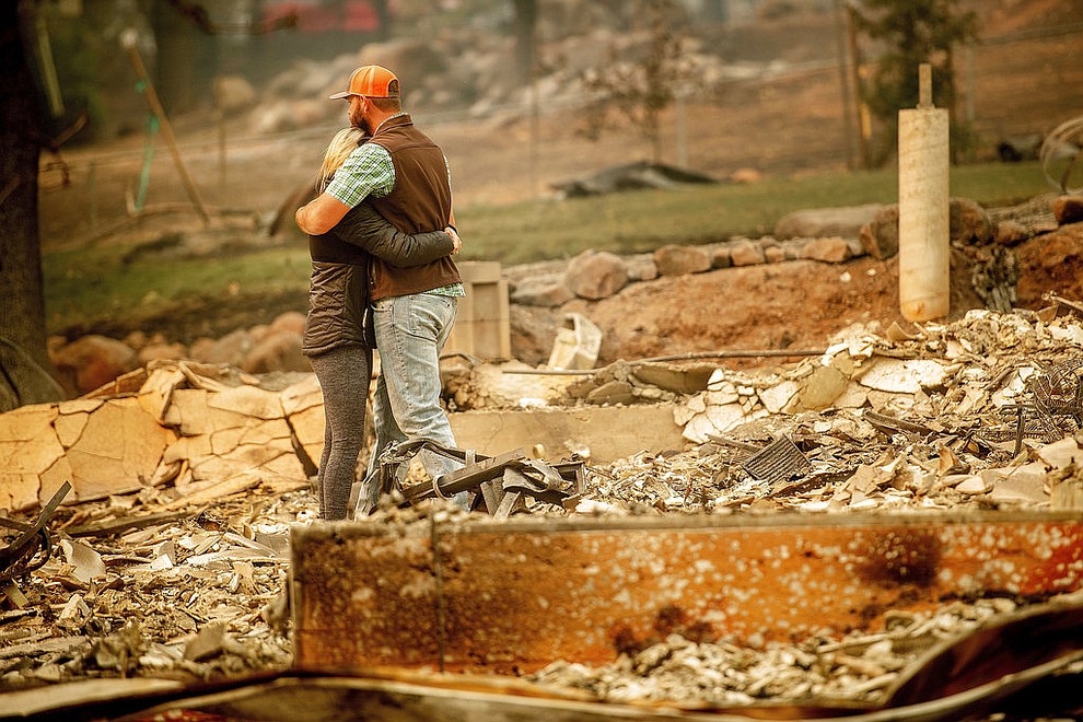 Chris and Nancy Brown embrace while searching through the remains of their home, leveled by the Camp Fire, in Paradise, Calif., on Monday, Nov. 12, 2018. As the fire approached, Nancy Brown escaped from the home with her 2-year-old and three dogs. (AP Photo/Noah Berger)