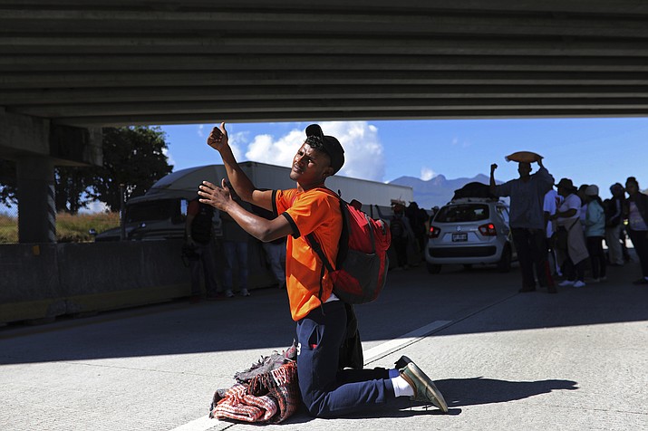 A Central American man who is traveling with a migrant caravan heading for the U.S. border kneels to beg for a free ride on the highway connecting Guadalajara with Tepic, Mexico, Tuesday, Nov. 13, 2018. (Rodrigo Abd/AP)