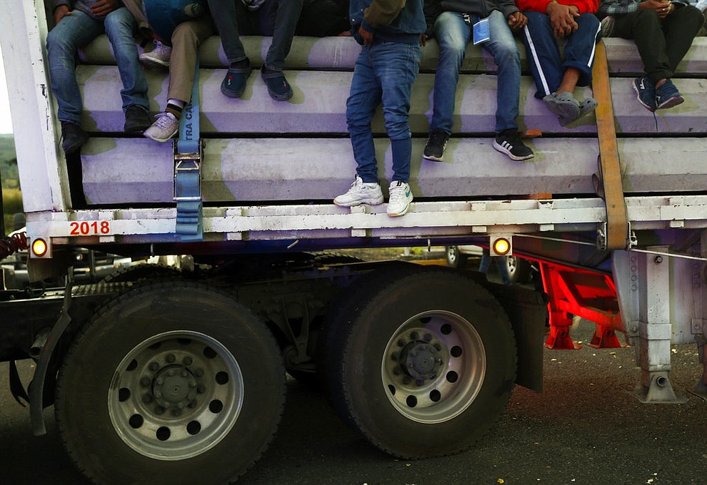Central American migrants moving as a caravan toward the U.S. border get a free ride on a truck at Ixtlán del Rio, Nayarit, Mexico, Tuesday, Nov. 13, 2018. The U.S. government said it was starting work Tuesday to "harden" the border crossing from Tijuana, Mexico, to prepare for the arrival of a migrant caravan leapfrogging its way across western Mexico. (AP Photo/Marco Ugarte)
