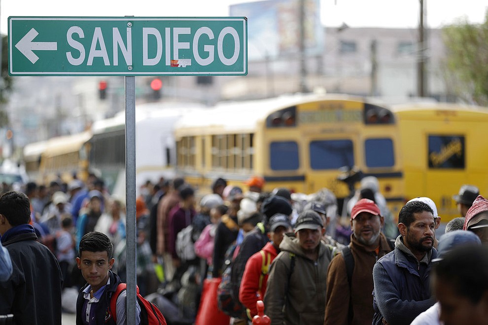 Central American migrants line up for a meal at a shelter in Tijuana, Mexico, Wednesday, Nov. 14, 2018. Migrants in a caravan of Central Americans scrambled to reach the U.S. border, catching rides on buses and trucks for hundreds of miles in the last leg of their journey Wednesday as the first sizable groups began arriving in the border city of Tijuana. (AP Photo/Gregory Bull)