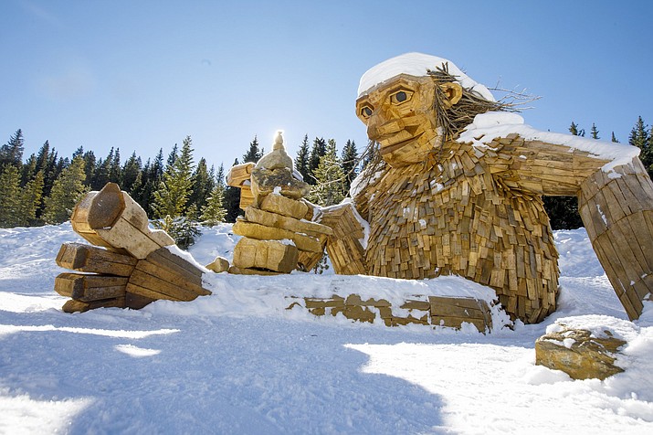 The large wooden troll, "Isak Hearthstone," made by artist Thomas Dambo during Breckenridge International Festival of the Arts in August, sits in the snow Wednesday, Nov. 14, 2018, along the Wellington Trail in Breckenridge, Colo. The troll was created during the Breckenridge Festival of the Arts in August, but got so popular that it caused complaints from nearby homeowners due to tourists visiting, and demanded it to be removed. (Hugh Carey/Summit Daily News via AP)