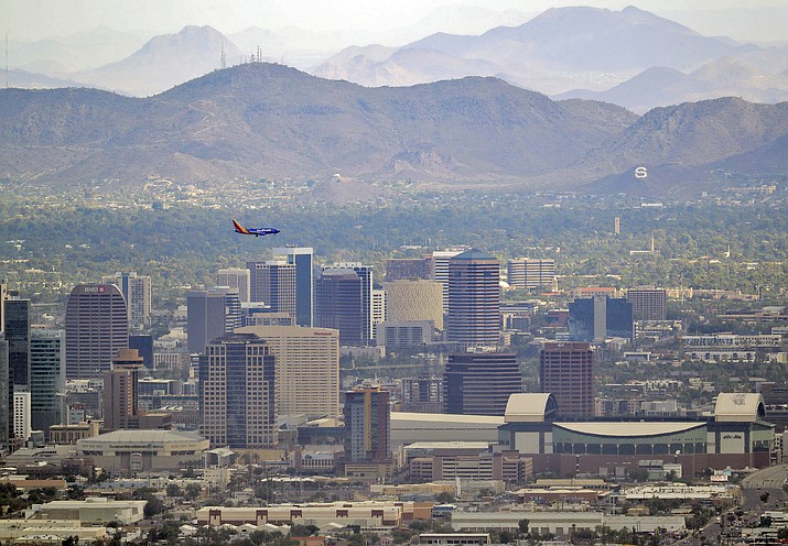 A jet comes in for approach over downtown Phoenix on Tuesday, July 24, 2018, as temperatures exceed 100 degrees in the morning hours. (Matt York/AP)
