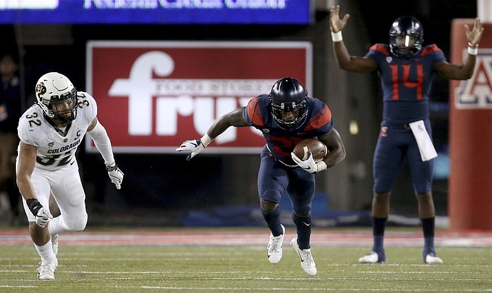 Arizona quarterback Khalil Tate (14) is impressed with teammate Arizona running back J.J. Taylor (21) after he juked and sped past Colorado linebacker Rick Gamboa (32) in the third quarter of an NCAA college football game Friday, Nov. 2, 2018, in Tucson, Ariz. (Kelly Presnell/Arizona Daily Star via AP)