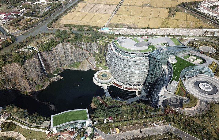 This Nov. 13, 2018, aerial photo and released on Thursday, Nov. 16, 2018 by Xinhua News Agency, shows the Intercontinental Shanghai Wonderland Hotel in Songjiang district of Shanghai, east China. The 18-story hotel has been built into the side of a huge hole in the ground left by a former put mine with sixteen of its floors below ground level. (Fang Zhe/Xinhua via AP)