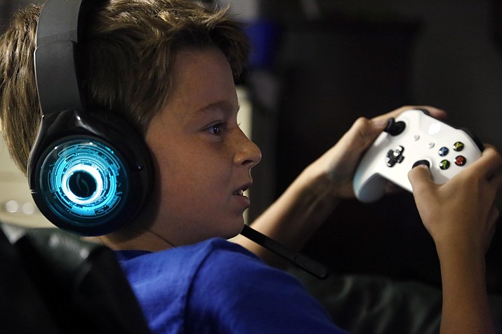 Henry Hailey, 10, plays the online game Fortnite in the early morning hours of Saturday, Oct. 6, 2018, in the basement of his Chicago home. His parents are on a quest to limit screen time for him and his brother. The boys say they understand sometimes, but also complain that they get less screen time than their friends. (Martha Irvine/AP)
