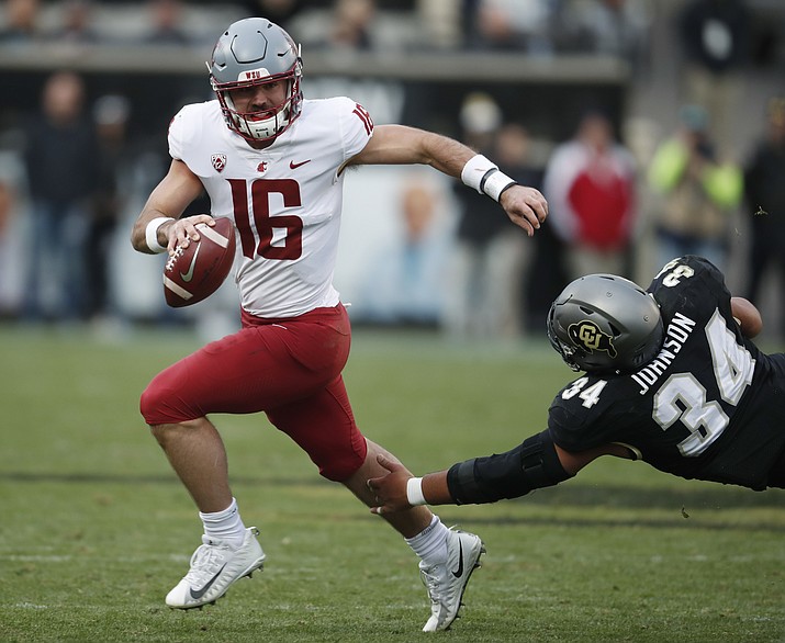 In this Nov. 10, 2018, file photo, Washington State quarterback Gardner Minshew, left, scrambles away from Colorado defensive lineman Mustafa Johnson in the second half of an NCAA college football game, in Boulder, Colo. Minshew nearly decided to spend this season at Alabama, where he almost certainly would have backed up Tua Tagovailoa the entire year. The East Carolina graduate transfer instead chose Washington State and has emerged as one of Tagovailoa’s top competitors for the Heisman Trophy. (David Zalubowski/AP, File)