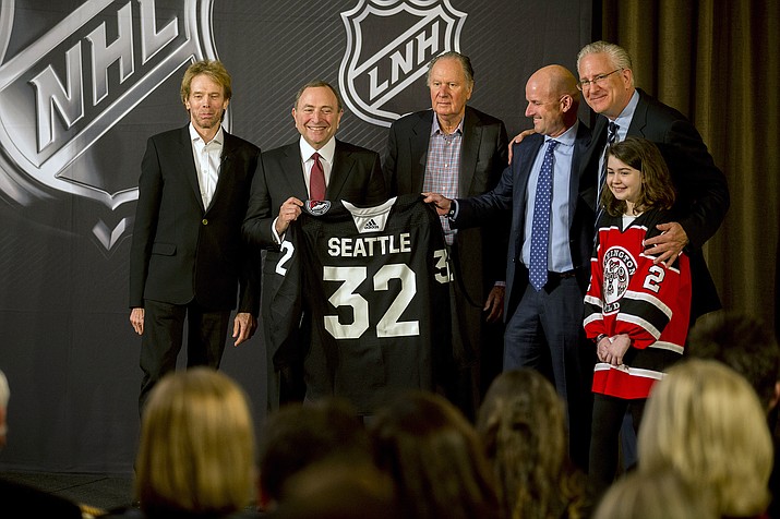 NHL commissioner Gary Bettman, center left, holds a jersey after the NHL Board of Governors announced Seattle as the league's 32nd franchise, Tuesday, Dec. 4, 2018, in Sea Island Ga.. Joining Bettman, from left to right, is Jerry Bruckheimer, David Bonderman, David Wright, Tod Leiweke and Washington Wild youth hockey player Jaina Goscinski. (Stephen B. Morton/AP)