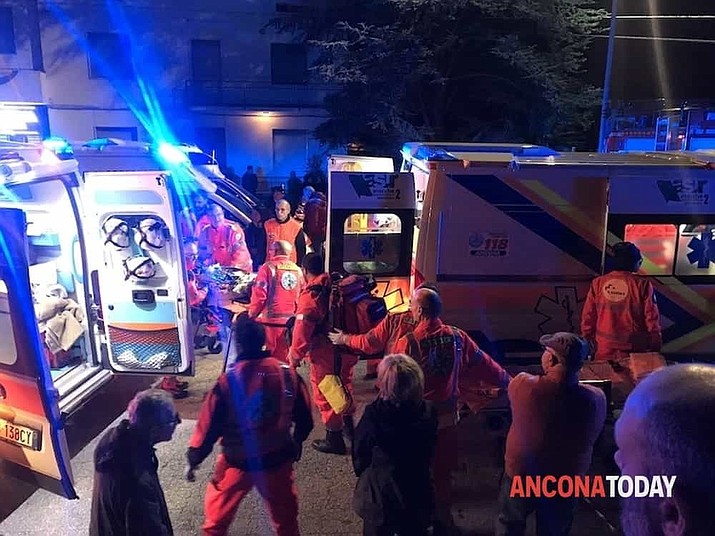Rescuers assist injured people outside a nightclub in Corinaldo, central Italy, early Saturday, Dec. 8, 2018. At least six people, all but one of them minors, were killed and about 35 others injured in a stampede of panicked concertgoers early Saturday at a disco in a small town on Italy's central Adriatic coast. (Stefano Pagliarini/Ancona Today via AP)