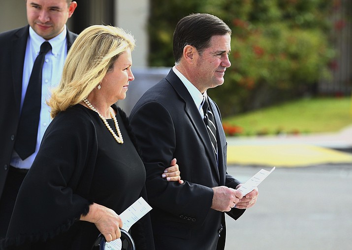 Arizona Republican Gov. Doug Ducey, right, is joined by his wife Angela as they arrive for the funeral of former Democratic U.S. Rep. Ed Pastor Friday, Dec. 7, 2018, in Phoenix. (Ross D. Franklin/AP)