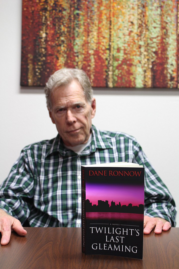 Kingman's Dane Ronnow shows a copy of his book, "Twilight's Last Gleaming," a thriller about the nation's electrical grid and infrastructure being completely shut down after a nuclear attack. The book goes on sale Saturday for $14 on Amazon. (Photo by Hubble Ray Smith/Daily Miner)