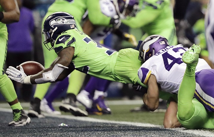 Seattle Seahawks' Chris Carson, left, dives into the end zone for a touchdown against the Minnesota Vikings in the second half of an NFL football game, Monday, Dec. 10, 2018, in Seattle. (Ted S. Warren/AP)