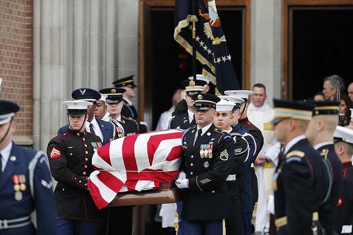 A military honor guard carries the flag-draped casket of former President George H.W. Bush from St. Martin's Episcopal Church following his funeral service Thursday, Dec. 6, 2018, in Houston. (AP Photo/Gerald Herbert)