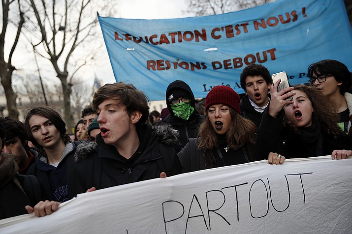 Students opposing changes in key high school tests demonstrate with a banner reading "We are education" Tuesday Dec.11, 2018 in Paris. French President Emmanuel Macron has acknowledged he's partially responsible for the anger that has fueled weeks of protests in France, an unusual admission for the leader elected last year. (Christophe Ena/AP)