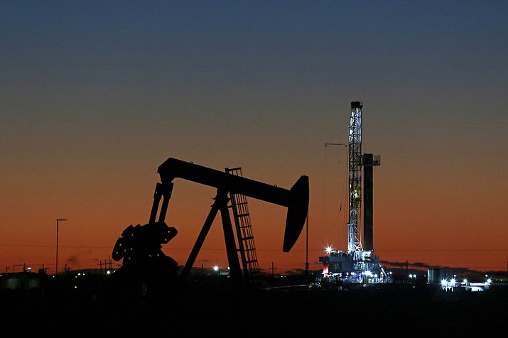 This Oct. 9, 2018, file photo shows an oil rig and pump jack in Midland, Texas. After a turbulent two months during which oil prices plummeted from a four-year high to a one-year low, investors may wonder what comes next for U.S. crude. (Jacob Ford/Odessa American via AP, File)