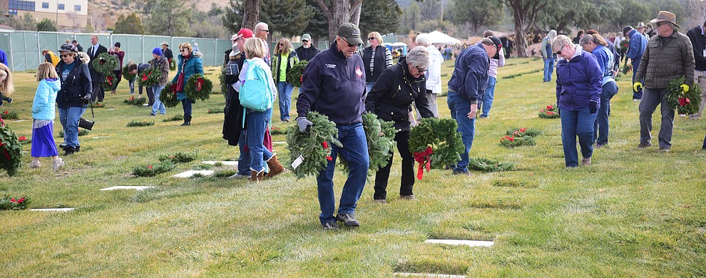 People place wreaths during the Wreaths Across America ceremony where 2106 veteran remembrance wreaths at the Prescott National Cemetery Saturday, Dec. 15, 2018. (Les Stukenberg/Courier).