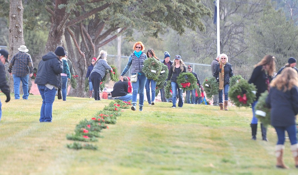 People place wreaths during the Wreaths Across America ceremony where 2106 veteran remembrance wreaths at the Prescott National Cemetery Saturday, Dec. 15, 2018. (Les Stukenberg/Courier).