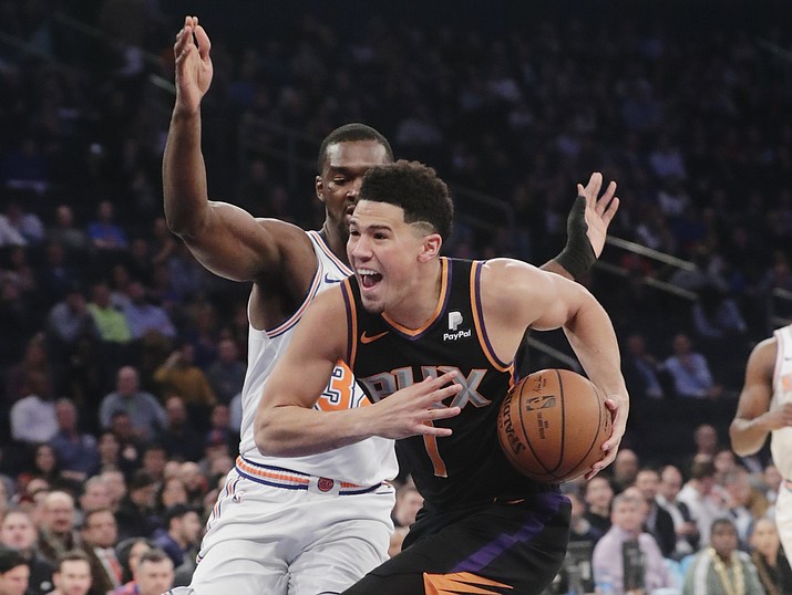 Phoenix Suns' Devin Booker (1) drives past New York Knicks' Noah Vonleh during the first half of an NBA basketball game Monday, Dec. 17, 2018, in New York. (Frank Franklin II/AP)