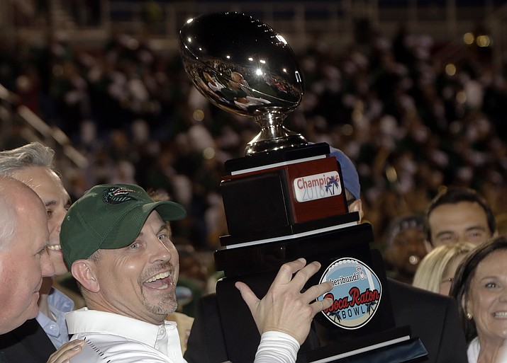 UAB head coach Bill Clark holds the trophy after winning the Boca Raton Bowl NCAA college football game against Northern Illinois, Tuesday, Dec. 18, 2018, in Boca Raton, Fla. UAB won 37-13. (AP Photo/Lynne Sladky)